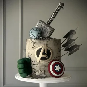 Avengers-themed birthday cake with Thor’s hammer, Hulk’s fist, Iron Man’s arc reactor, Captain America’s shield, and arrows