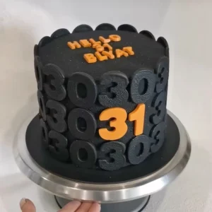Black fondant Matrix-style birthday cake with 3D numbers and bold orange “31”