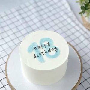 Minimalist aesthetic cake with blue brushstroke number “13” and handwritten “happy birthday” text