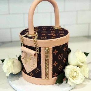 Luxury LV handbag cake with blush pink details, edible gold zipper, and white roses