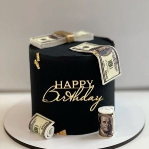 Black birthday cake with edible money decorations and gold accents