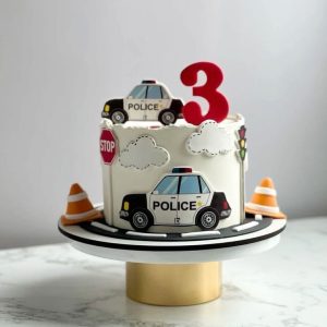Police-themed kids birthday cake with printed police car and traffic sign toppers